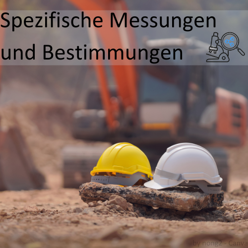 Zwei Sicherheitshelme auf einer Baustelle mit einem Bagger im Hintergrund und der Beschriftung „Spezifische Messungen und Bestimmungen“